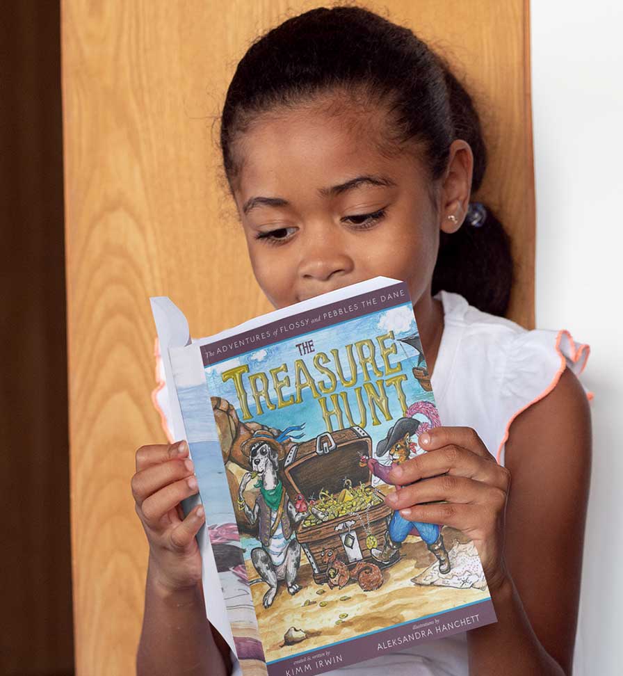 smiling young African American girl reading The Adventures of Flossy and Pebbles the Dane