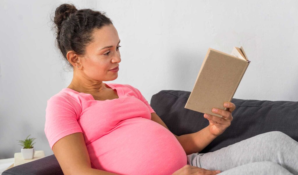 Beautiful pregnant woman reading to her unborn child