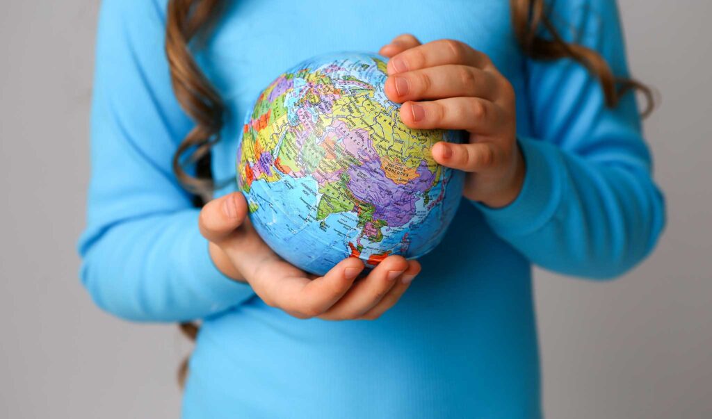 hands of young girl holding a globe
